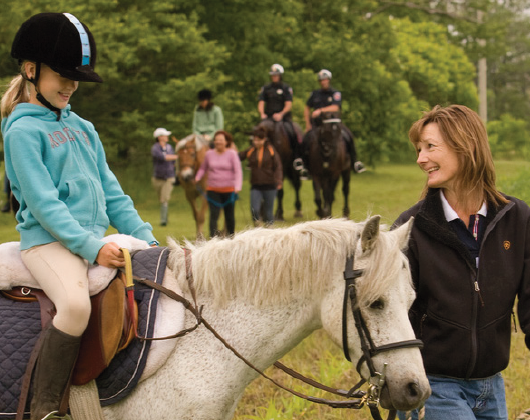 Some riders on a trail walk outside the barn with our dedicated instructors and volunteers.