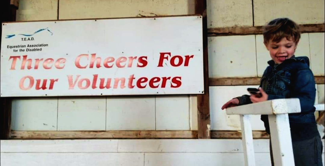 A rider with our "Three Cheers for our Volunteers!" banner in the background. 