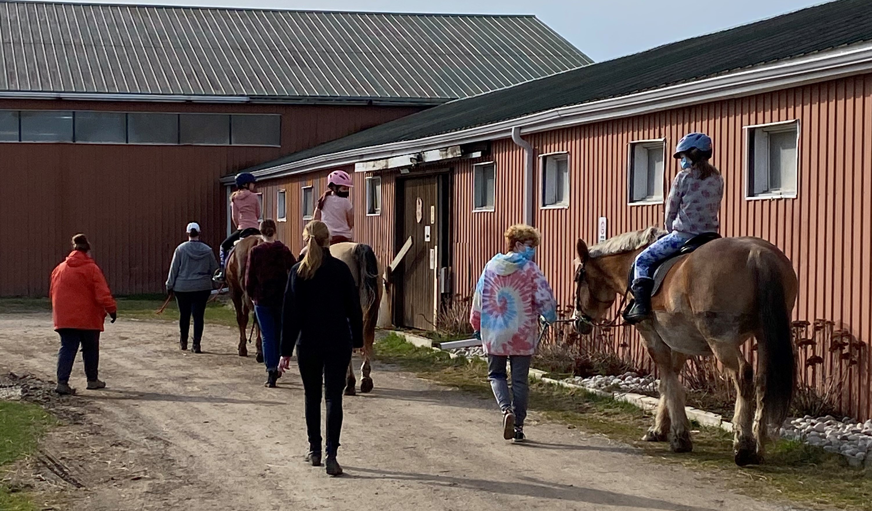 Some riders on a trail walk outside the barn with our dedicated instructors and volunteers.