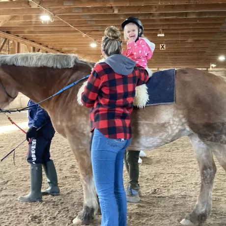 A small rider mounted on Lexi, smiling with delight!