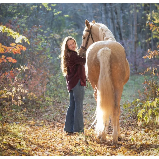 Kylie and her horse, Taffy, in an autumn wood.